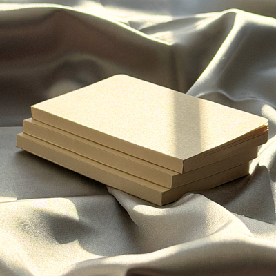 Stack of beige books on a textured fabric surface