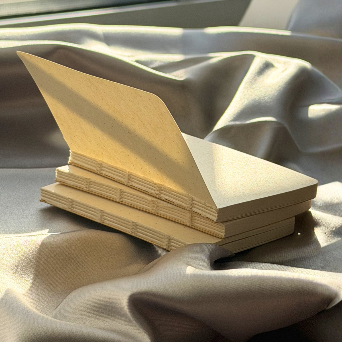 Stack of beige cardboard boxes on a textured surface